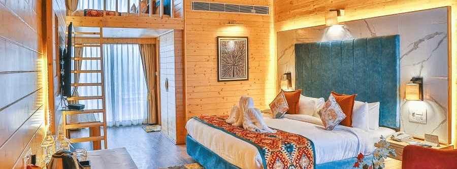 A cosy room with a plush bed, and warm lighting. A ladder leads to a loft area. - Bamboo Saa Resort & Spa, Udaipur