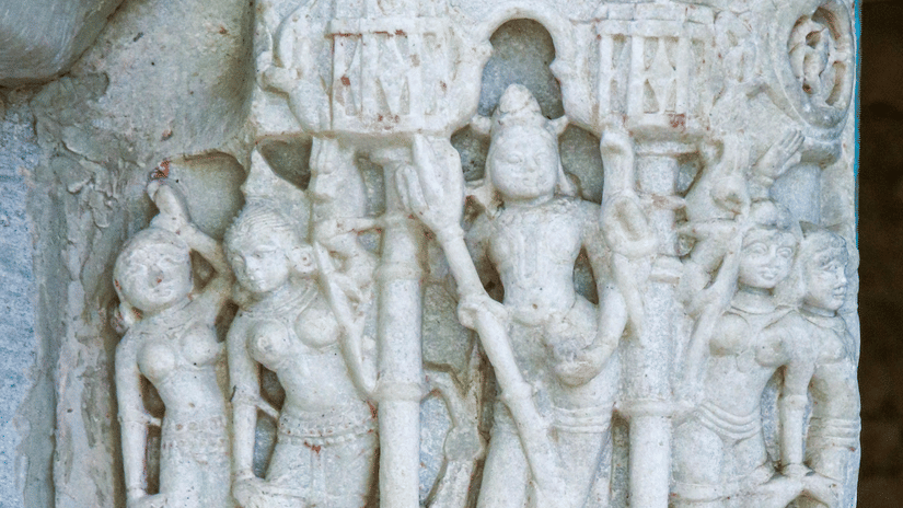 Close-up of hand-carved stone relief depicting Vishnu and attendant figures on the outer wall of Jagdish Temple Udaipur