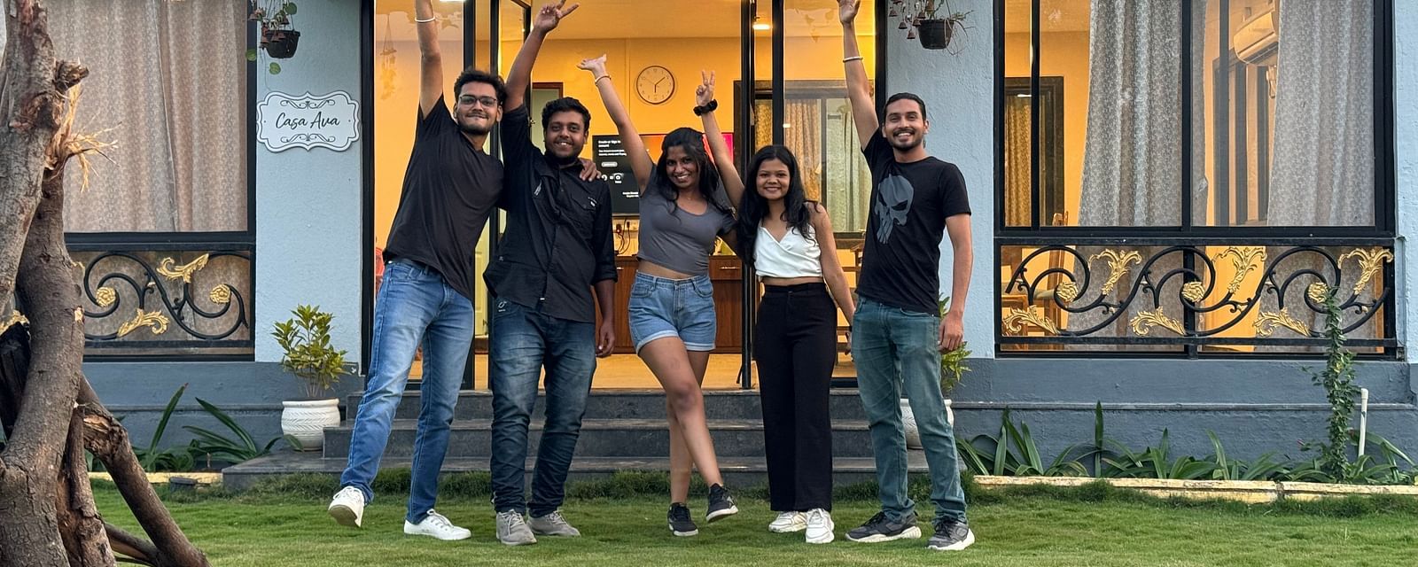 Group of friends posing joyfully in front of a hostel at sunset | Diamond Parks, Pune 