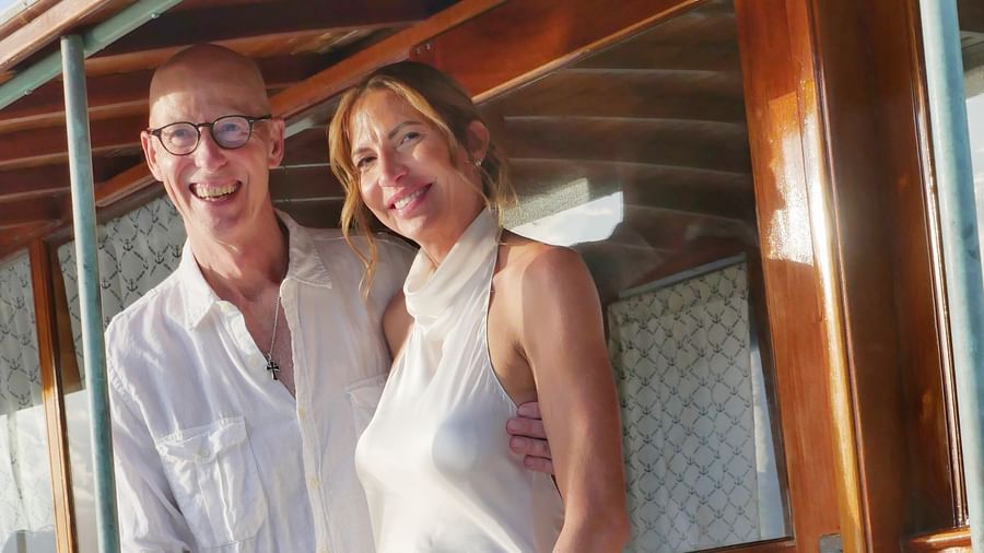A bright shot of a couple standing together on a wooden boat deck overlooking the ocean at Casa Morada.