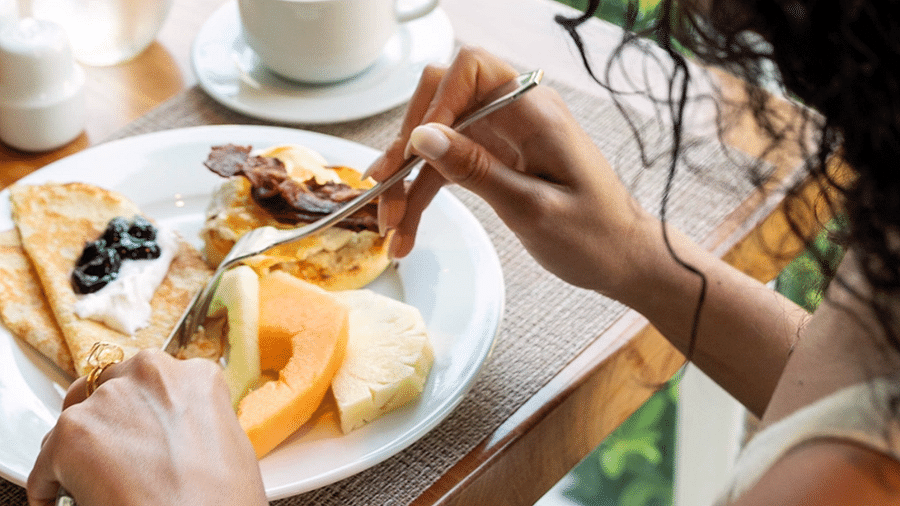 A woman enjoying a delicious dish severed at our restaurant - S Hotel Montego Bay, Jamaica