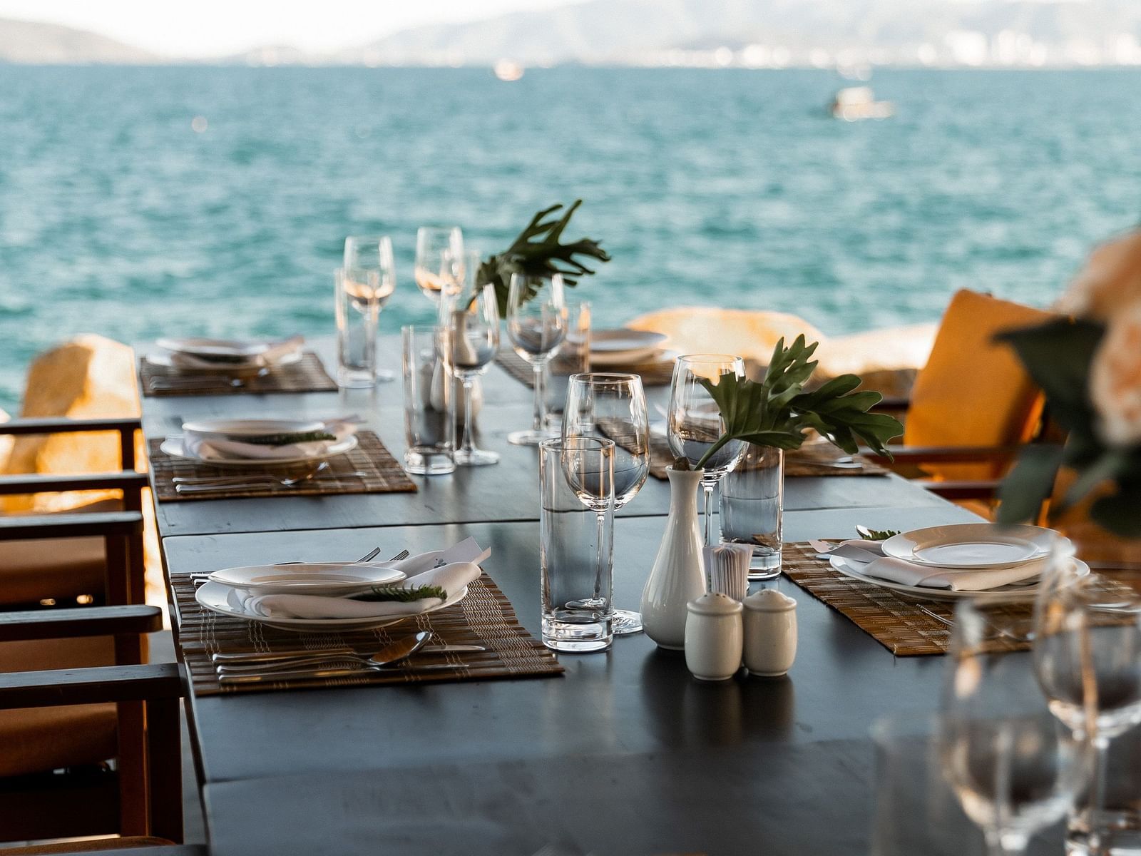 A neatly arranged table with a side of beautiful view of the Nha Trang bay - Alibu Resort Nha Trang