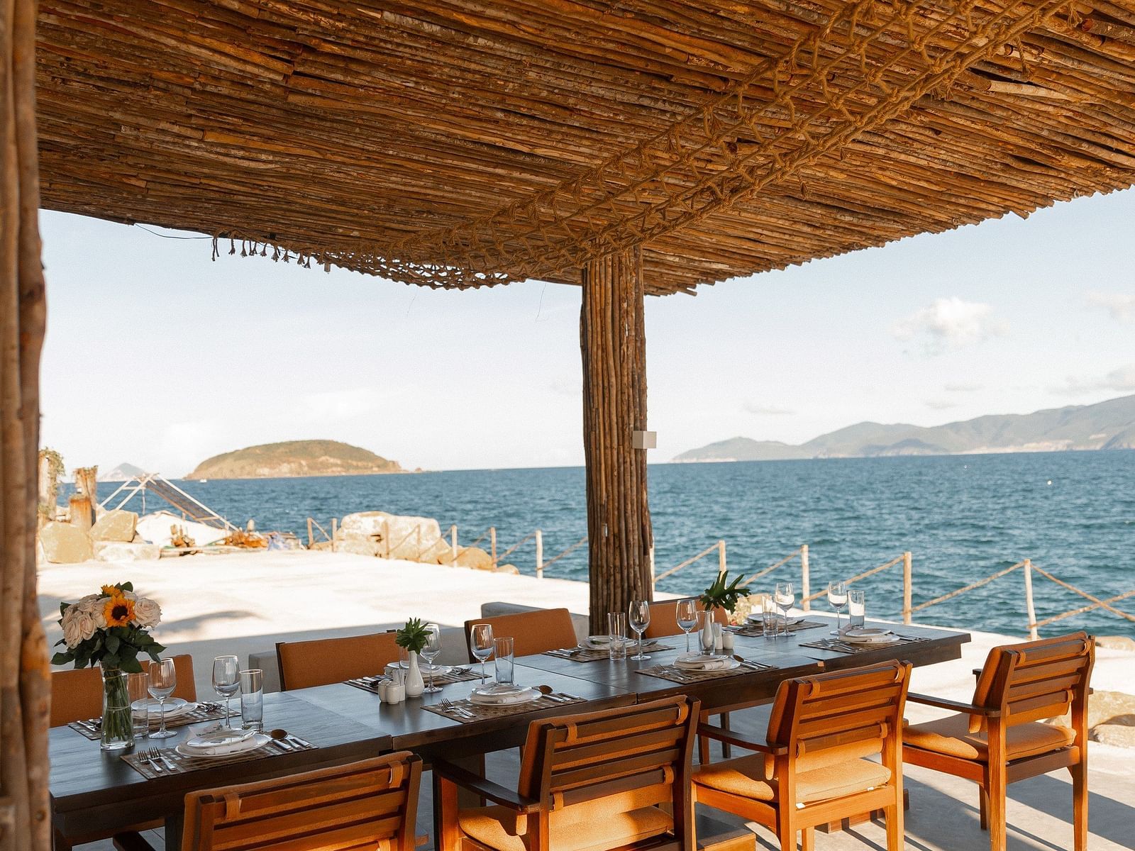 A seating arrangement by the bay of Nha Trang bay under a wooden shack - Alibu Resort Nha Trang