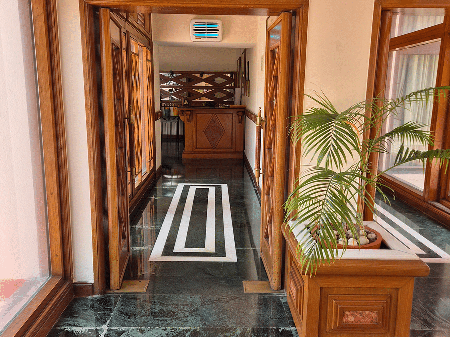 Image of the Jacaranda entrance passage, featuring a decorative plant and a beautifully crafted wooden door at The Ummed Ahmedabad.