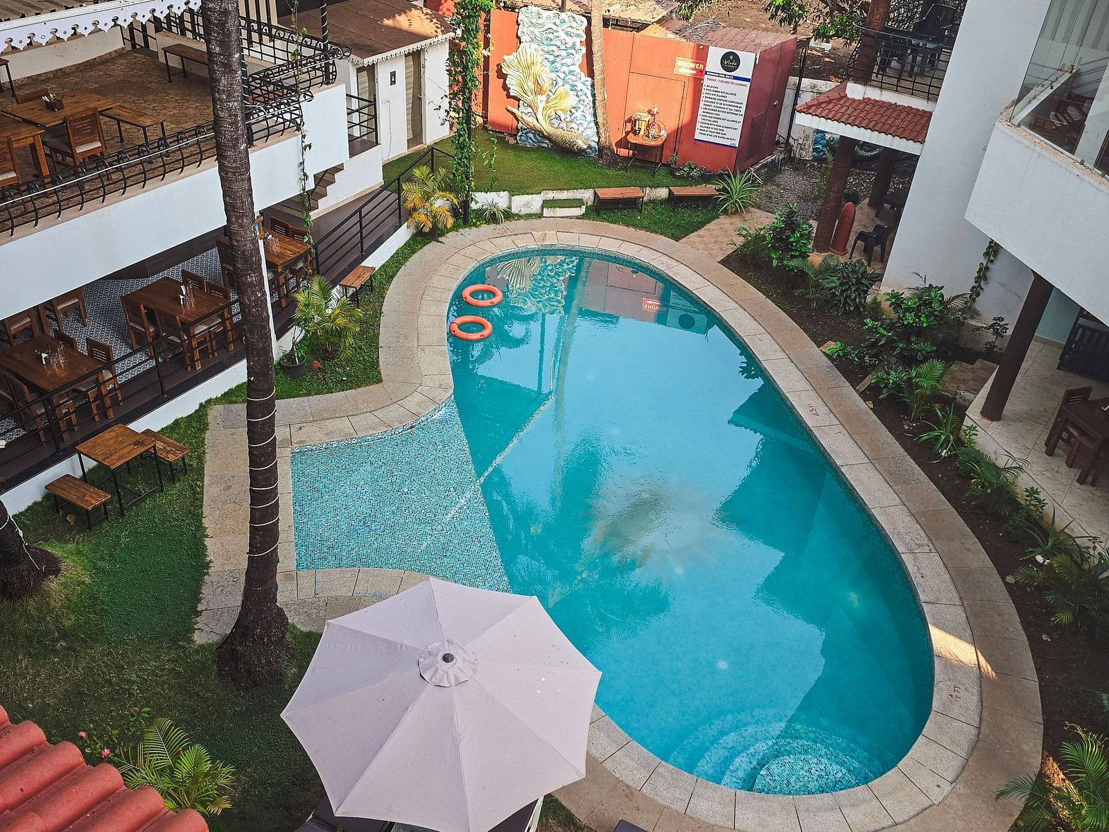 Top view of a narrow swimming pool bordered by loungers and umbrellas at The Verda de Miranda Resort.