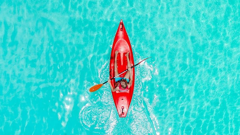 an aerial view of a person kayaking in azure water with ripples on the waterbody