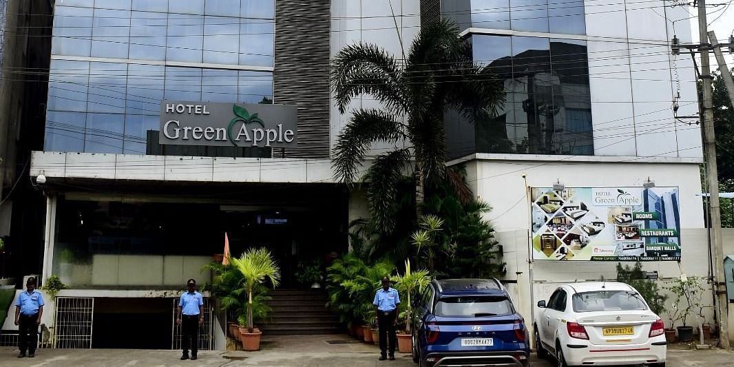 Facade of Hotel Green Apple with cars parked in front of it