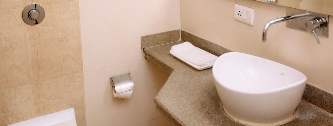 Bathroom at Hotel Diamond Inn, Chandigarh featuring western-style fixtures, towel rack, sink and clean tiling.