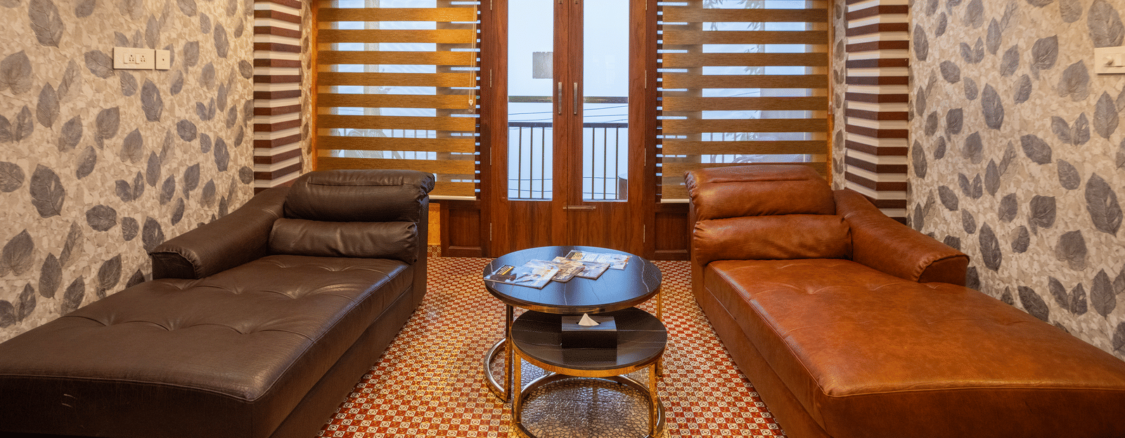 A living area in Double Bedroom Pool Villa at Parakkat Nature Hotel and Resorts, Munnar  featuring multi-seating sofa on either side of the room, a round center table and a modern ceiling with fan.