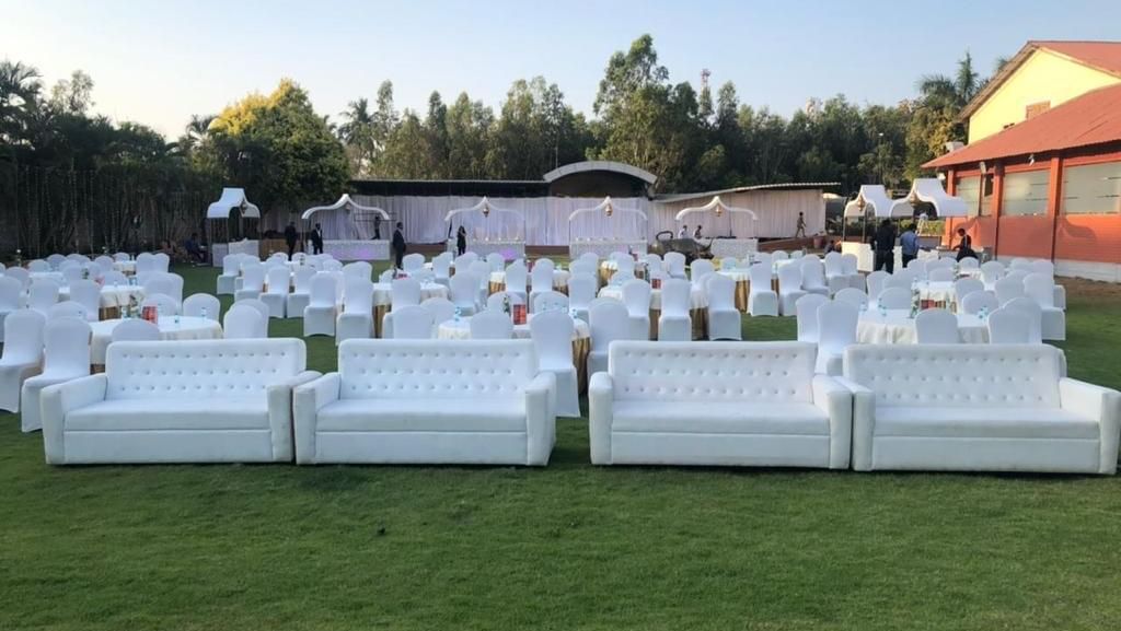 White sofa seating setup on the lawn for an outdoor event at Ilara Hotels & Spa, OMR, Chennai