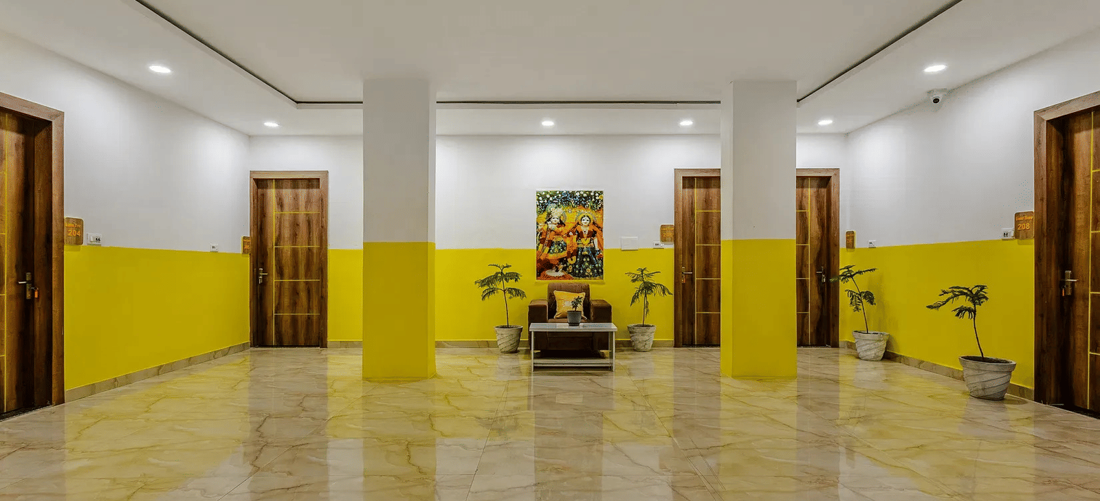 A large indoor hall with yellow and white walls, and minimal furnishings - Lime Tree Hotels & Banquet, Vrindavan
