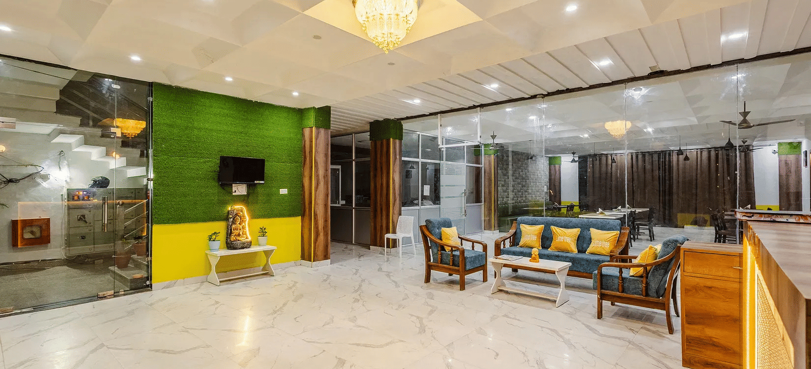A hotel lobby with seating area, green accent wall, and chandelier lighting - Lime Tree Hotels & Banquet, Vrindavan