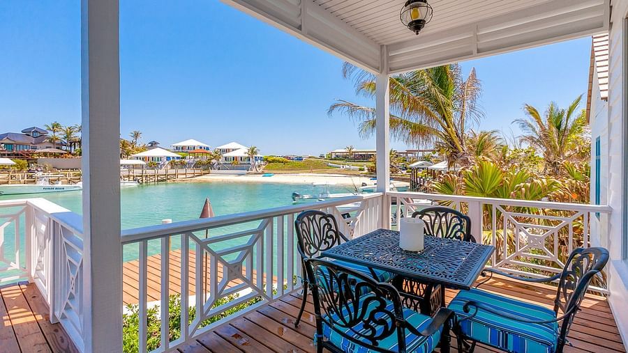 Outdoor dining table on a covered balcony with waterfront views | Abaco Inn