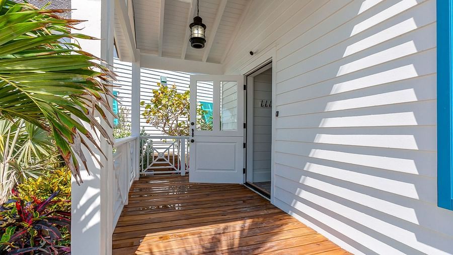A porch with wooden flooring and white walls | Abaco Inn