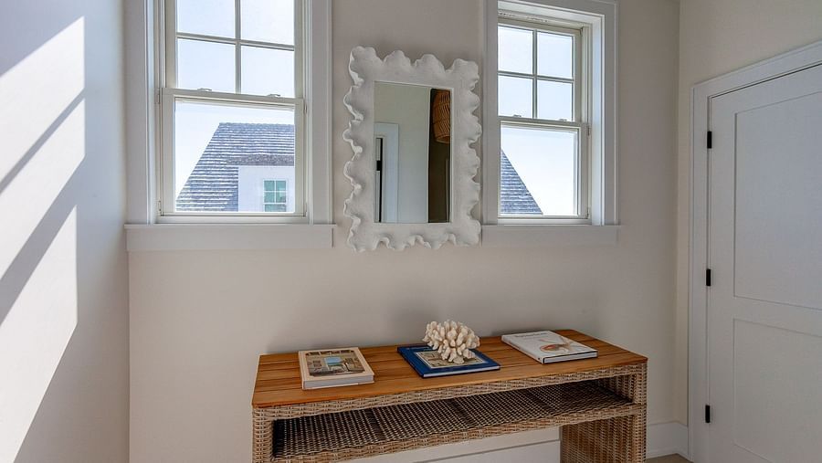 A wooden console table, mirror, and natural light streaming through windows | Abaco Inn