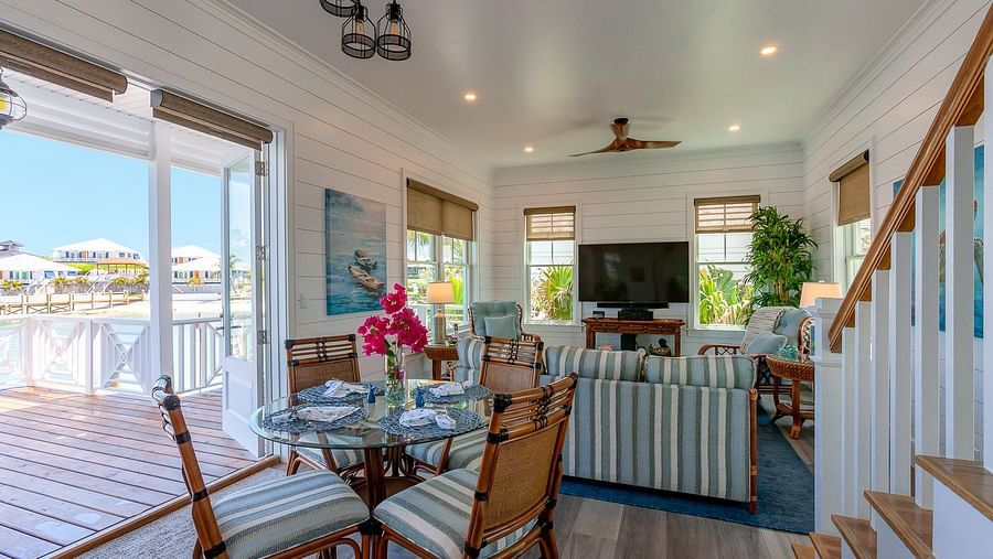 Dining area with glass doors opening to a deck with outdoor seating | Abaco Inn