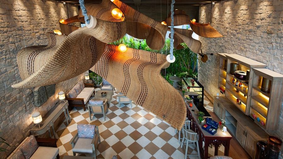 A top-angle shot featuring the unique chandelier hanging from the ceiling above the Suenos de Cafe at The Evren, Vagator.