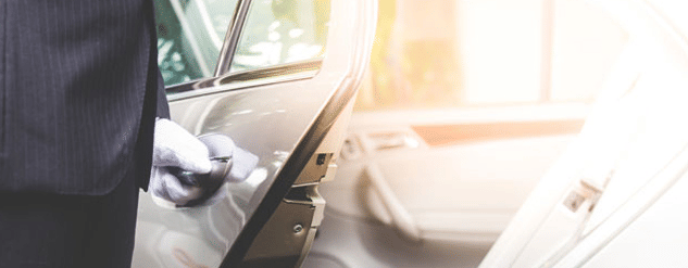 a chauffeur opening a door of a car