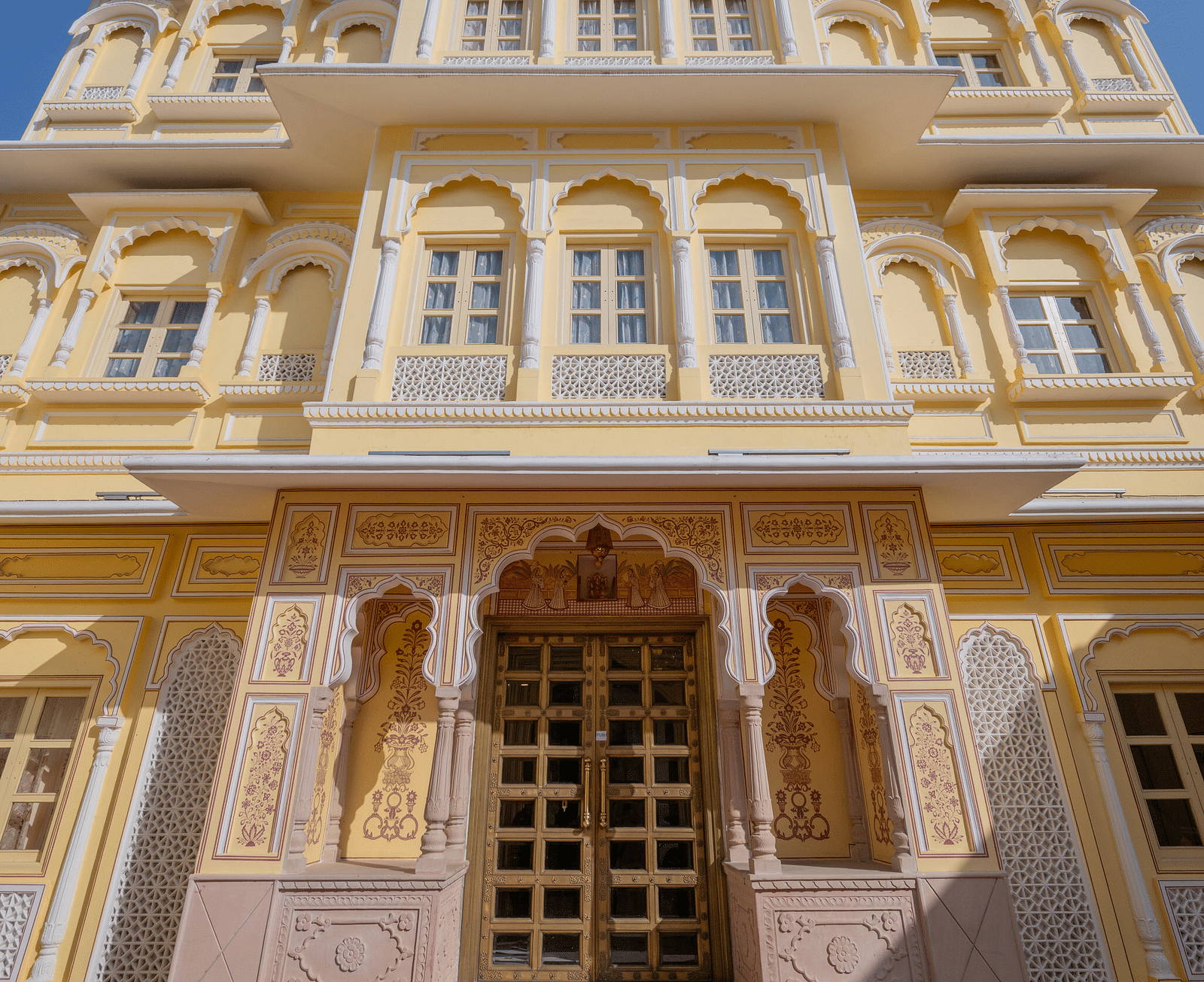 facade image of our hotel with sun rays illuminating the exterior - Brij Castle, Jaipur