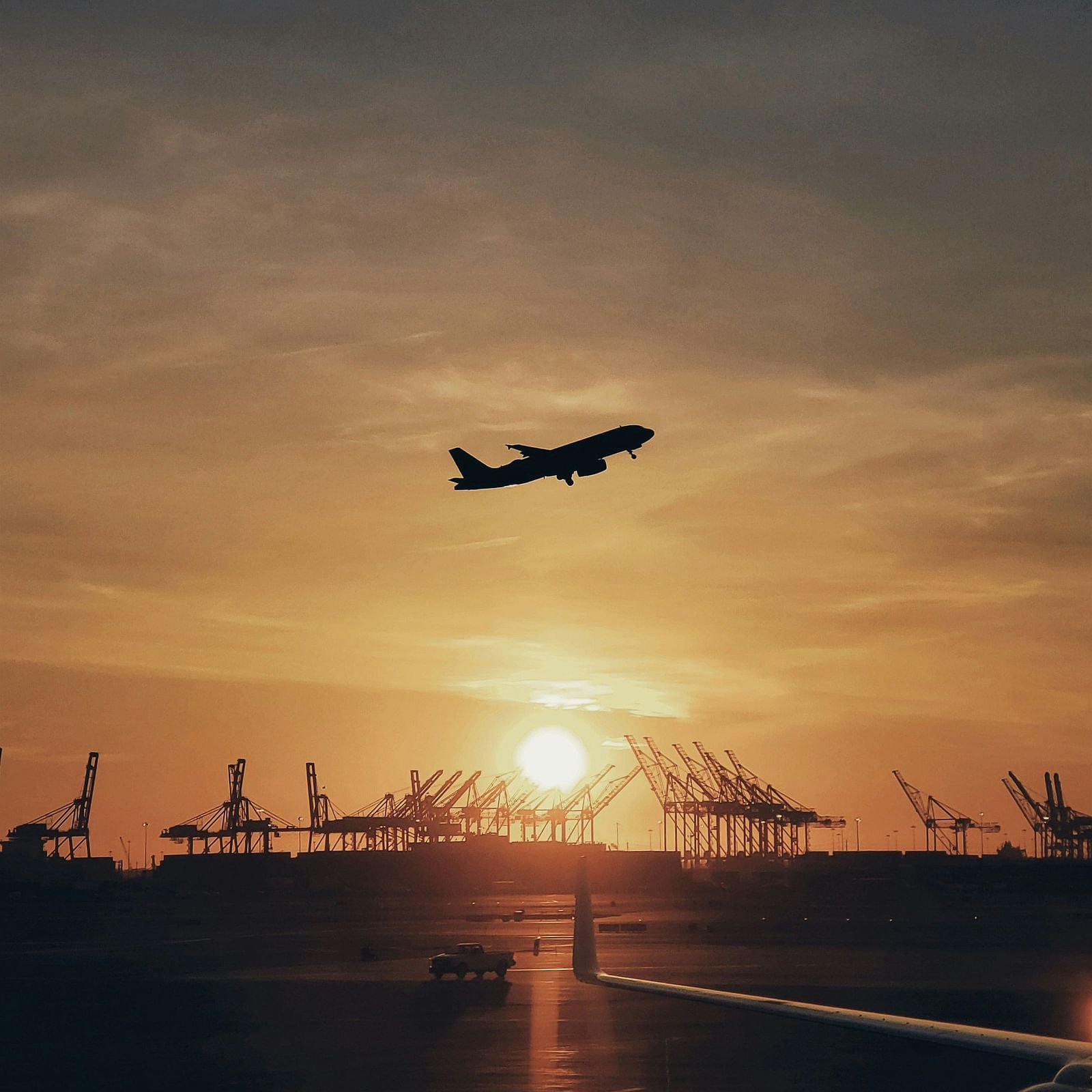 An image sunset with a plane flying.