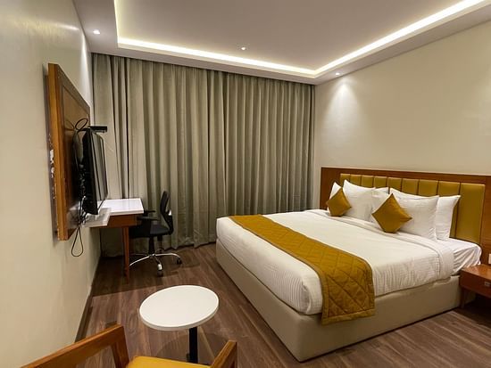 Bedroom with king size bed with white covers-  Quality Inn Rockwell Grand