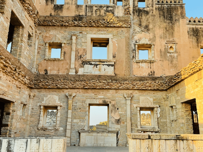 Chittorgarh Fort with carved windows and balconies, showcasing aged sandstone textures, symmetry, and intricate detailing from historic fort architecture