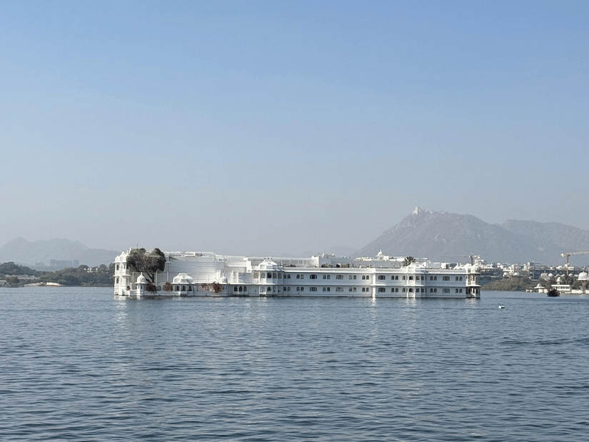 A palace situated in the middle of a lake beneath a clear blue sky.