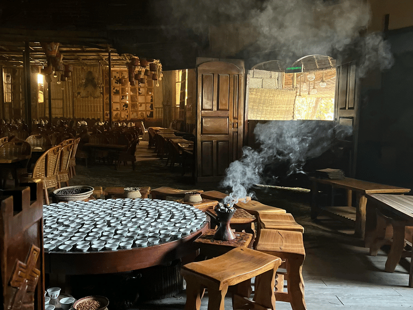 A traditional coffee house in Addis Ababa, where coffee beans are kept on the ground and numerous glasses kept inside a round table