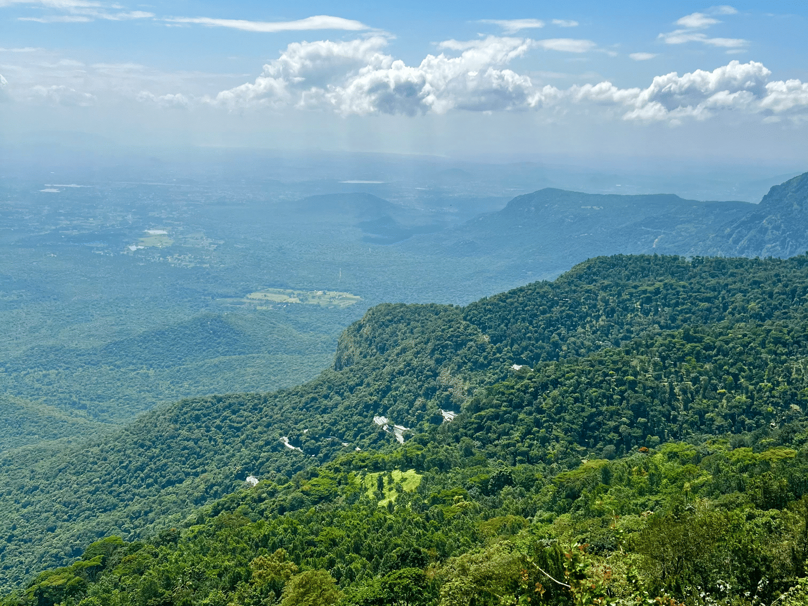 Vibrant green hills stretching across the landscape under bright daylight.