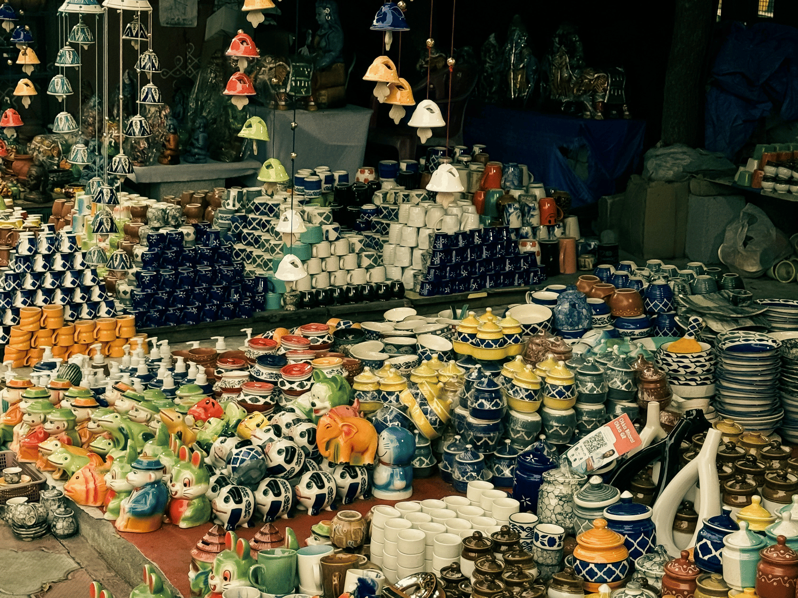 Market place in broad daylight with various china materials and art works kept in display for sale.