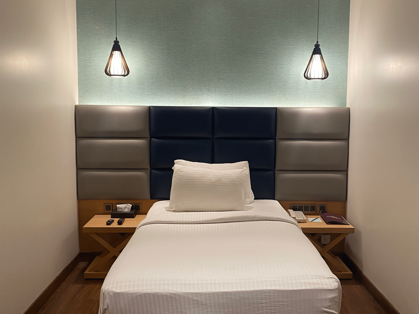 A comfortable bed with beautiful hanging light at SRM Hotel Maram Malai Nagar Chennai