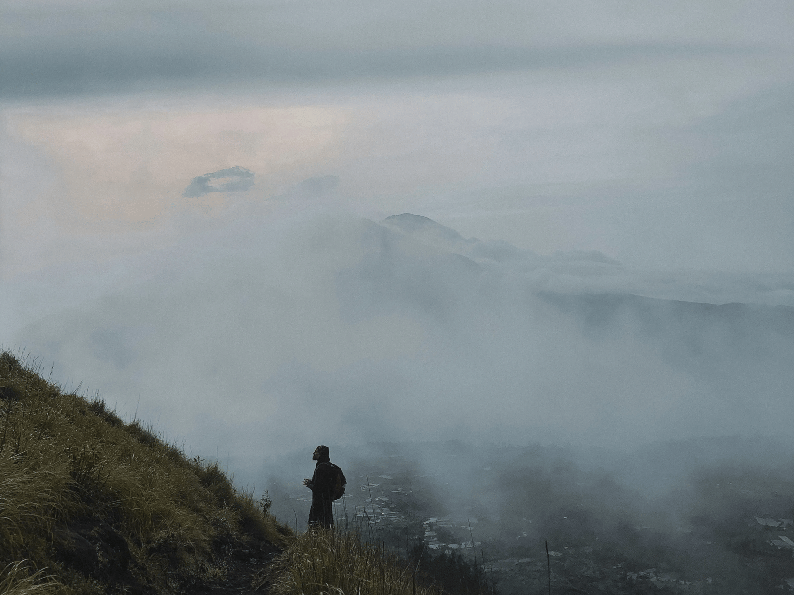 A person standing on a misty hill.