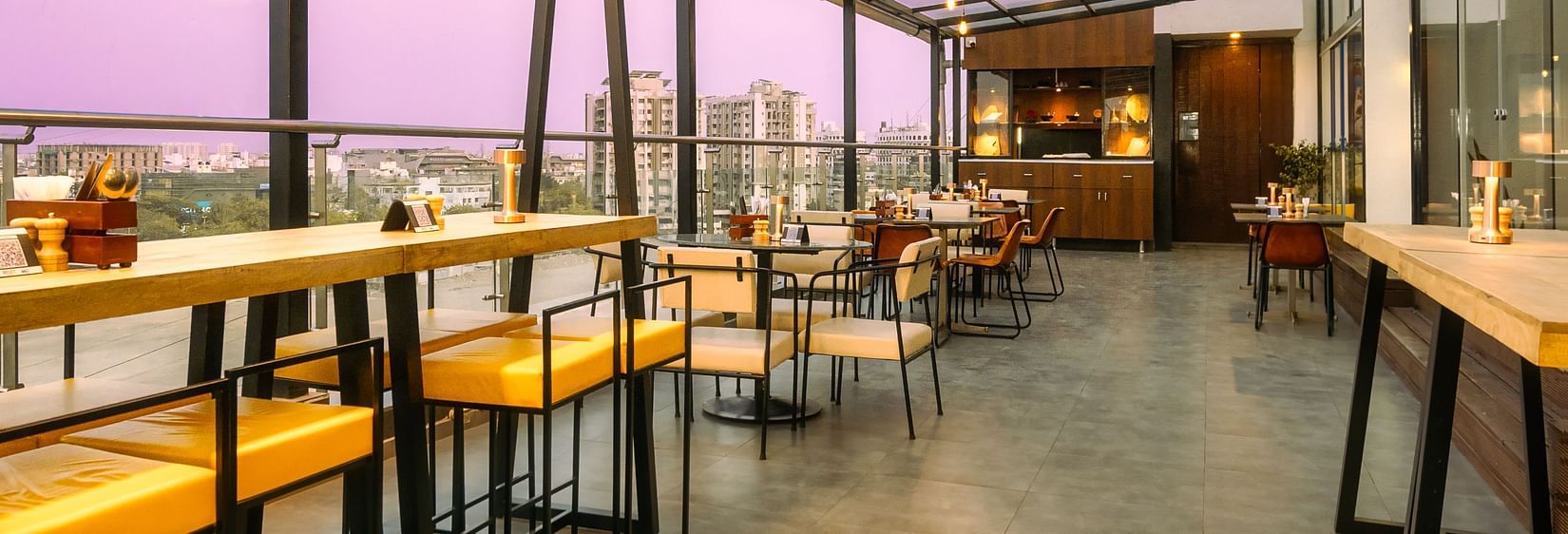  A long shot of the rooftop cafe with comfy seating and beautiful view at at Marasa Sarovar Portico, Rajkot