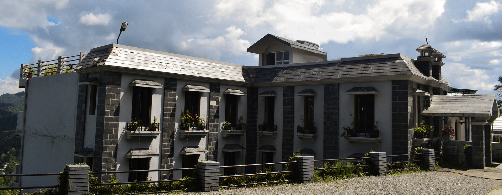 A wide view of the facade of a hotel in Kausani - Sun N Snow Inn, Kausani