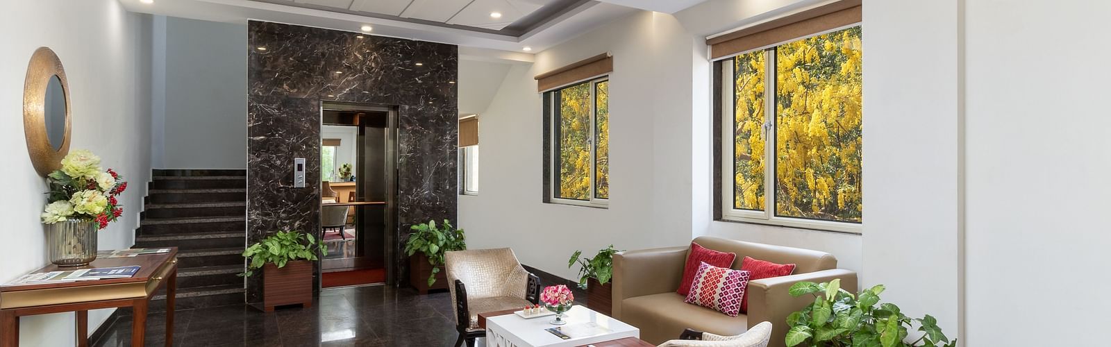 A spacious hotel lobby with comfortable seating, elegant decor, and plenty of natural light | Inde Hotel Cyber City