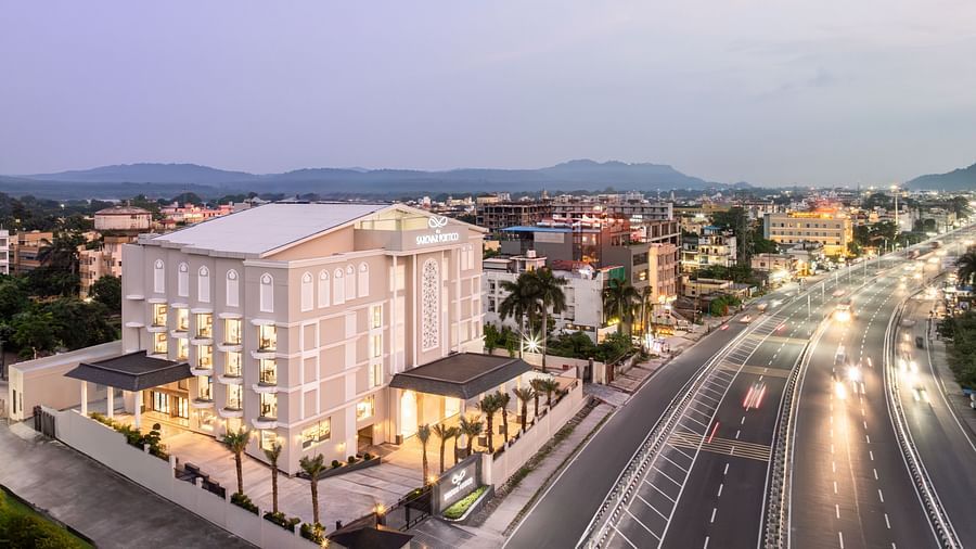 MJ Sarovar Portico hotel building alongside a bustling road, set against a scenic mountain view - MJ Sarovar Portico, Haridwar
