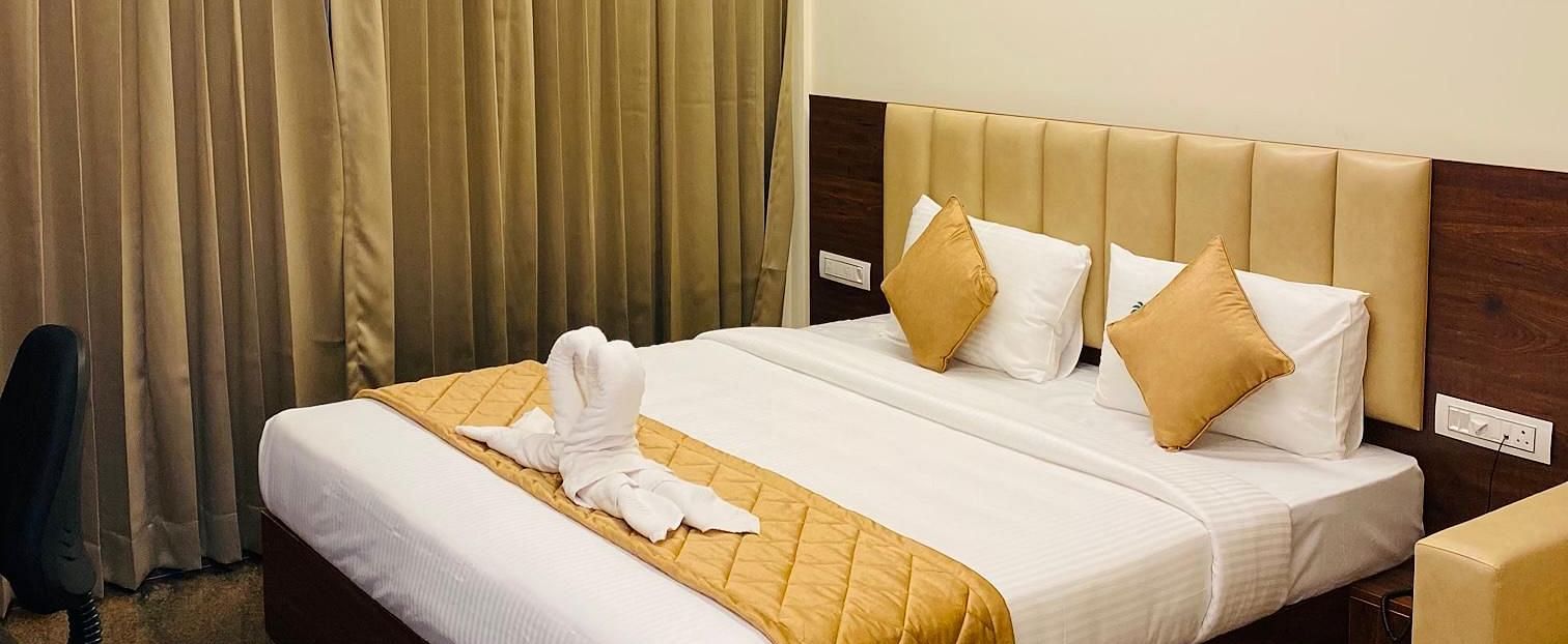 Comfortable room with golden accents, wooden furniture, and cosy lighting at Hotel Sahara Tree.