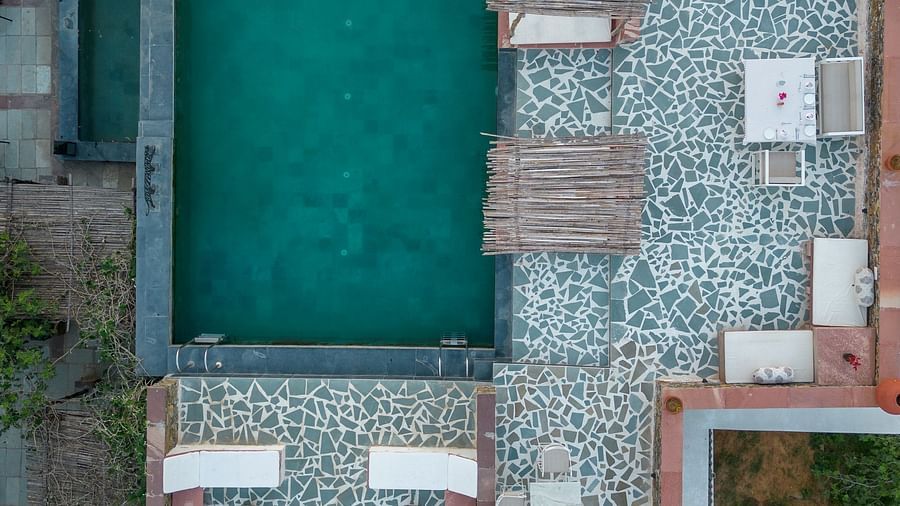 An aerial view image of a seating arrangement near the swimming pool in the open - Utsav Camp Sariska