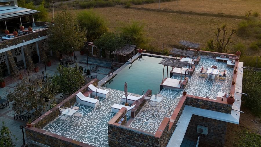 An aerial view image of a seating arrangement near the swimming pool in the open - Utsav Camp Sariska