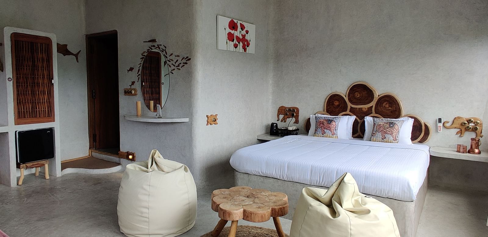 Marlin-6 - comfy bed accompanied by luxorious bean bags and a tea table, with the background in white painted walls.