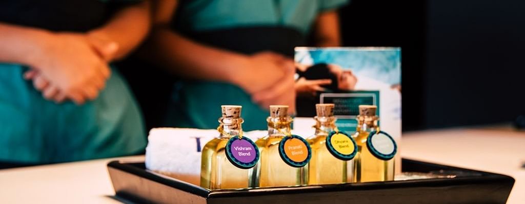 This image showcases a spa setting. A tray holds several small bottles of essential oils.