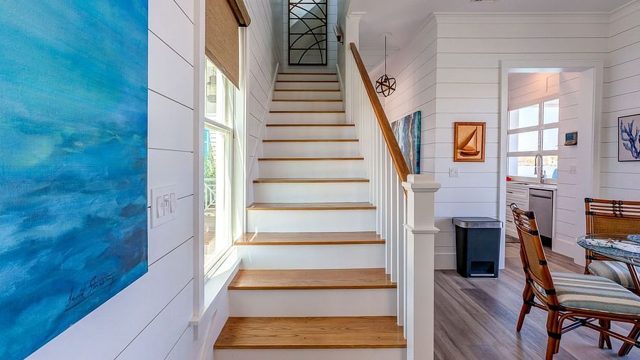 Wooden staircase with blue coastal artwork on the wall | Abaco Inn