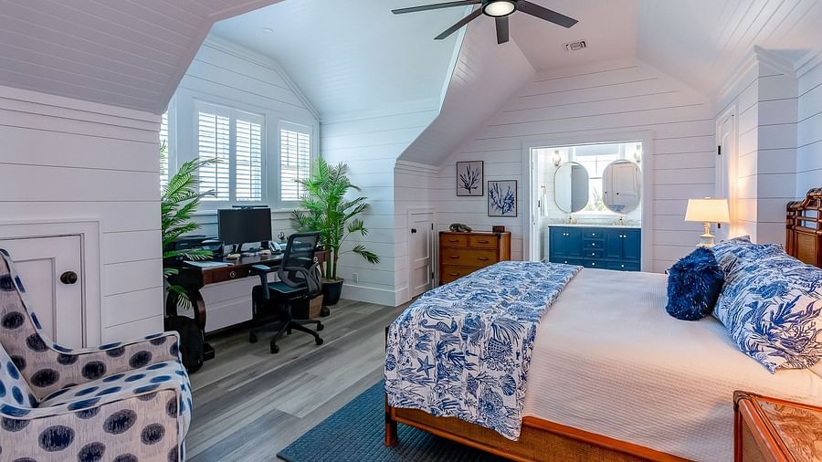 Spacious bedroom with a wooden bed, blue accents, and a ceiling fan | Abaco Inn
