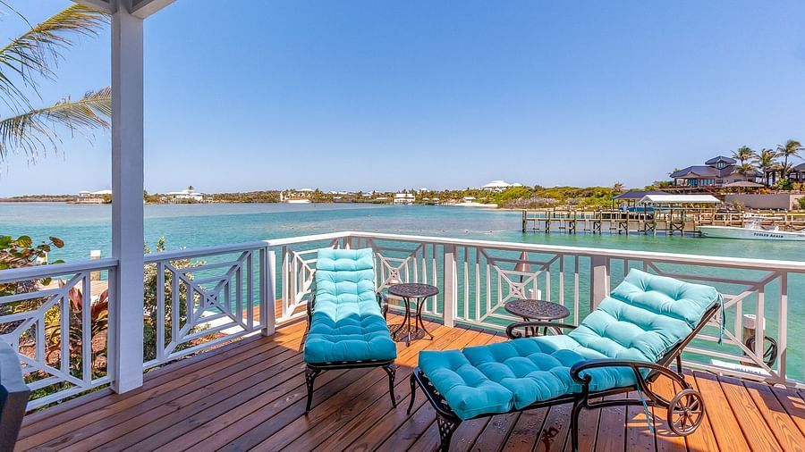 Wooden deck with blue sun loungers overlooking the water | Abaco Inn