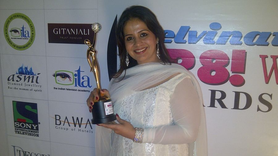 Kiran Bawa posing with an award - IOSIS Spa & Wellness