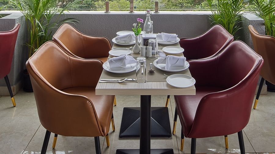 A close up shot of a dining table offering a view of the lush green trees surrounding the property