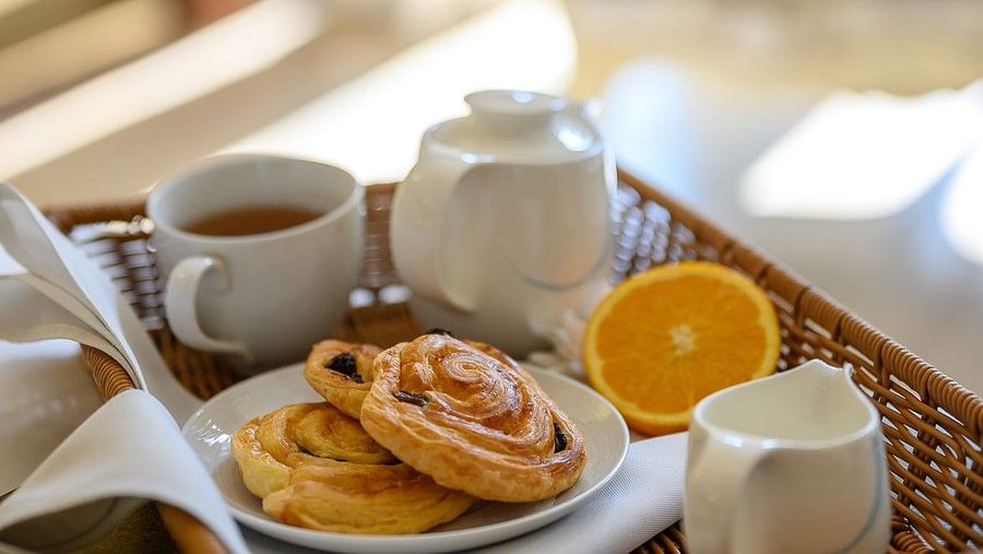 image of a breakfast spread served in bed on a wooden tray - Maikhao Dream Villa Resort & Spa, Phuket
