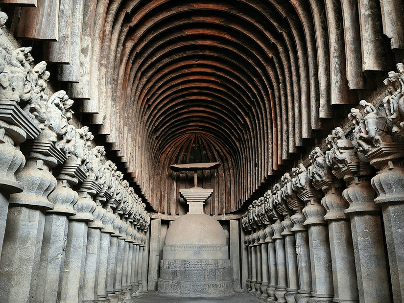 A view inside one of the Karla Caves, consisting of a Chaitya Hall with numerous pillars and arched ceiling. This cave is one of the Lonavala things to explore during your time here.