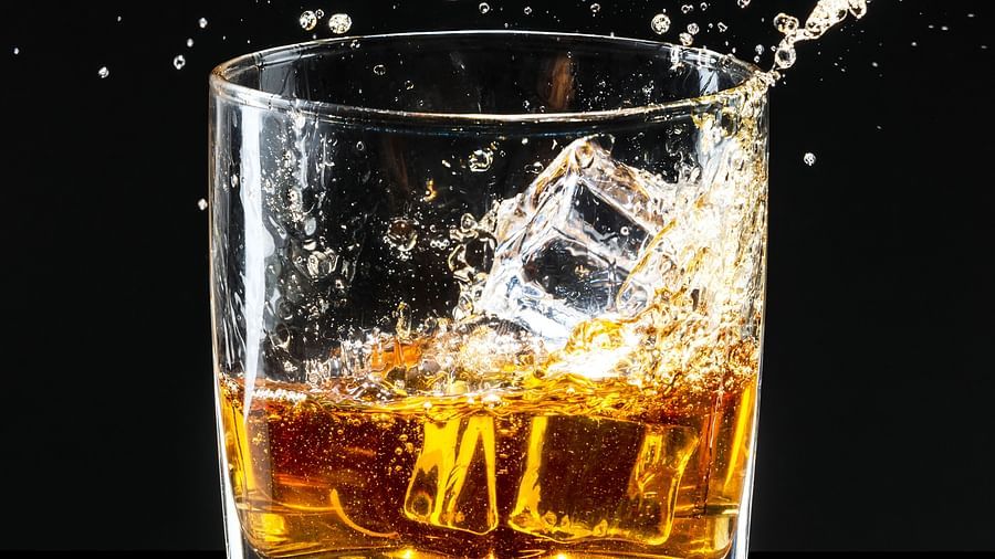 A whiskey glass with a splash, capturing the dynamic movement of the liquid - Themis Barbecue House, Ambience Mall, Gurugram