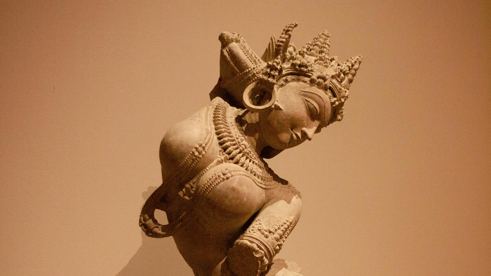 A small, ancient-looking statue of a figure in a seated or kneeling position.